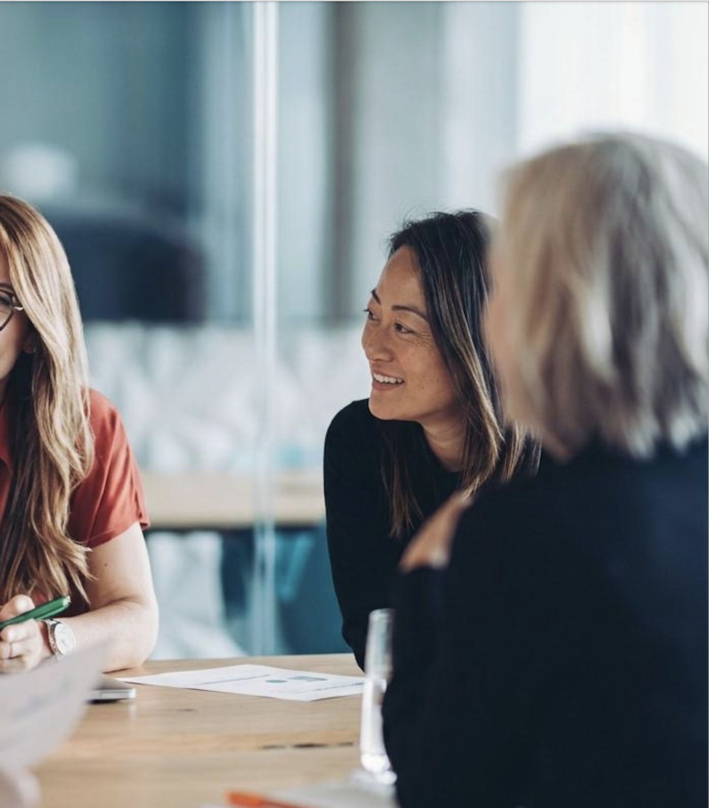 Yumy Pham in conversation with two colleagues in a meeting